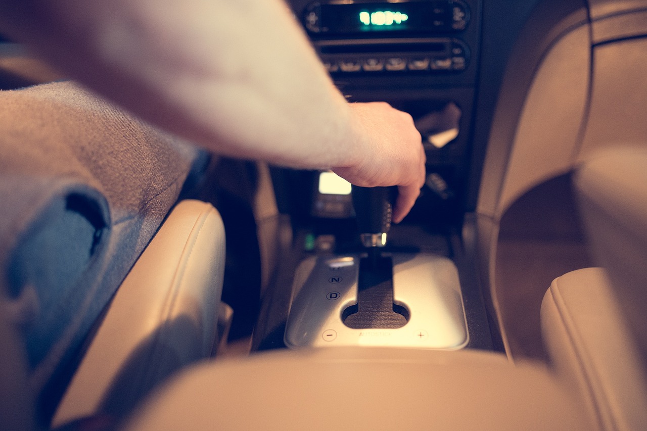 A person changing the gear shift in a car