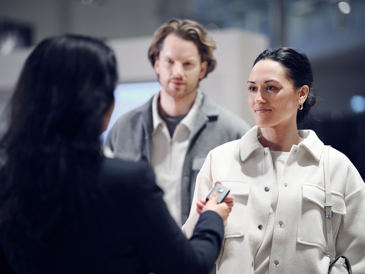 A woman handing car keys to a couple