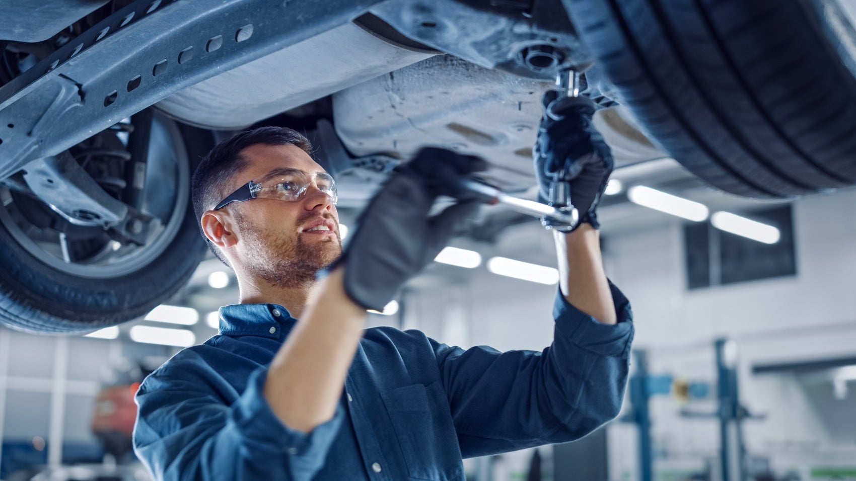Mechanic performing vehicle maintenance at a car service center
